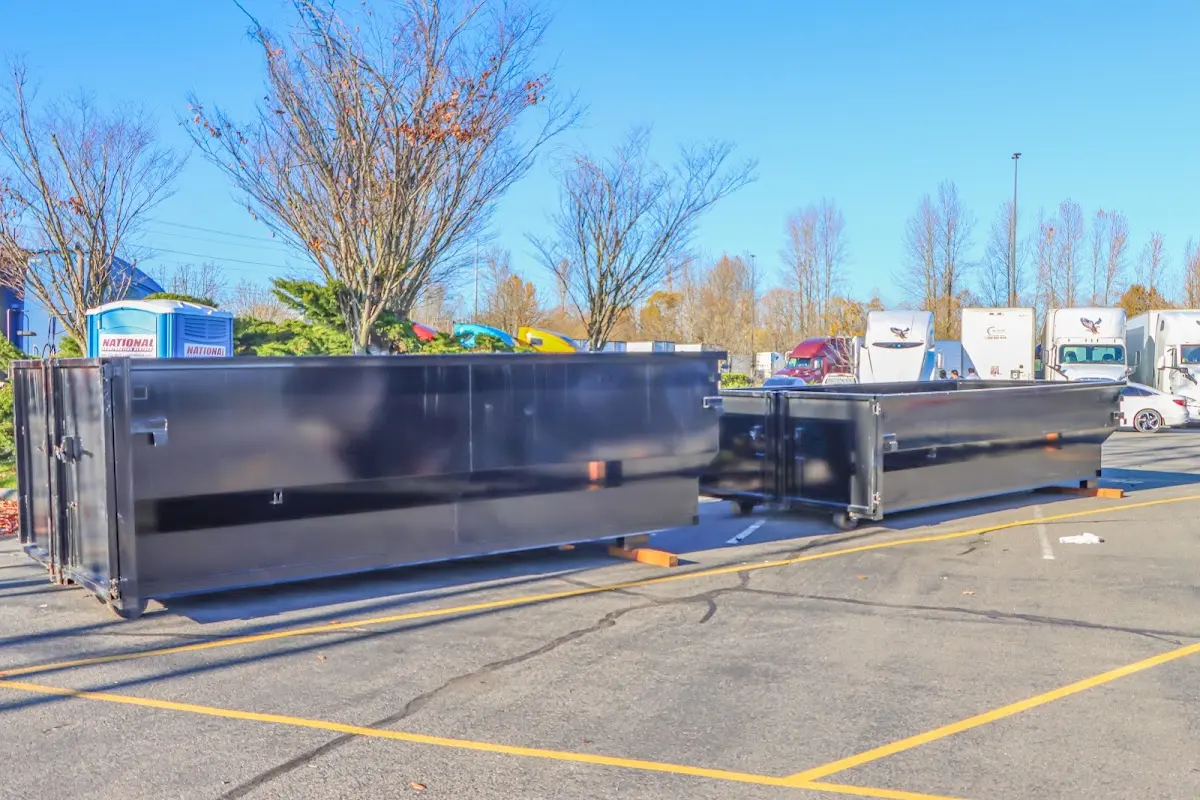 Professional dumpster rental service with roll-off container on residential driveway in Welcome